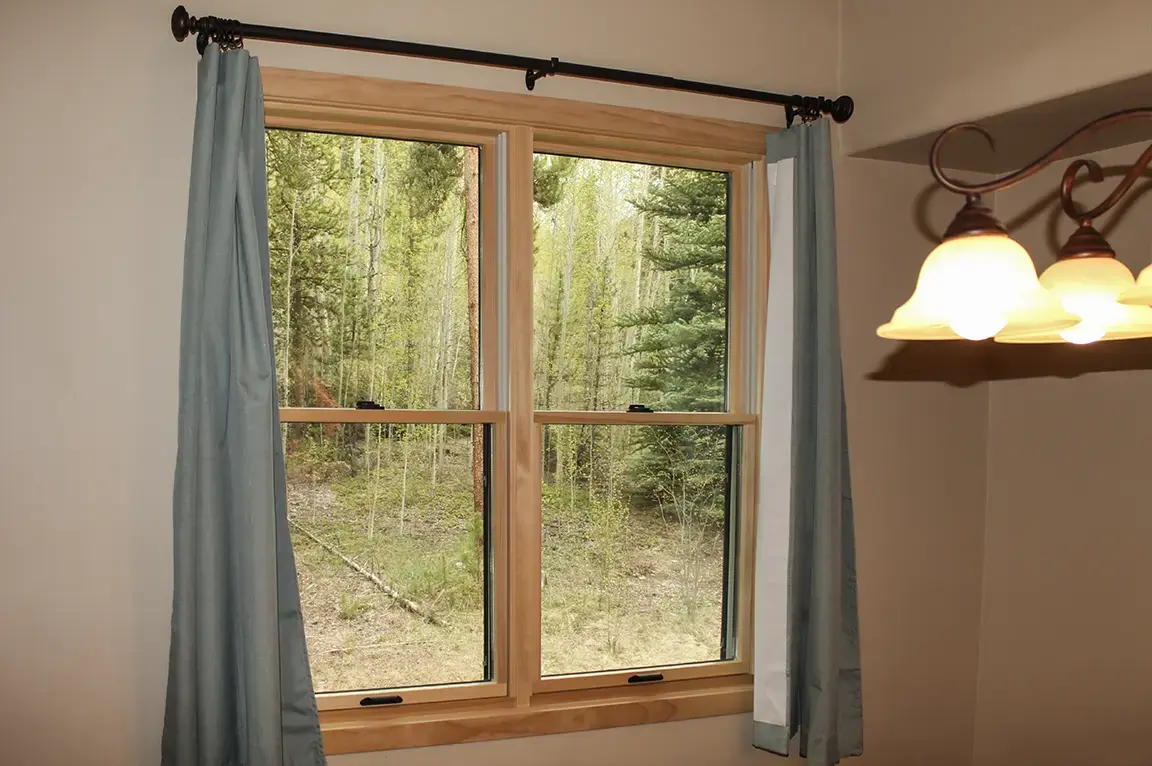 Sk pella wood frame window forest view blue curtains